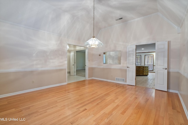 unfurnished dining area with a chandelier, wood-type flooring, high vaulted ceiling, and crown molding