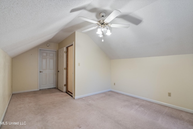 bonus room featuring a textured ceiling, light colored carpet, ceiling fan, and lofted ceiling