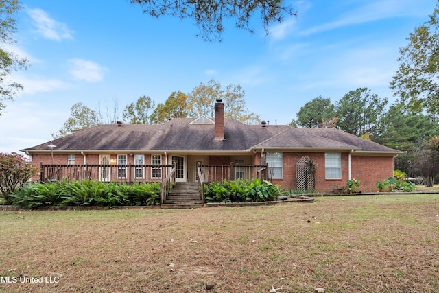 view of front of property with a deck and a front lawn