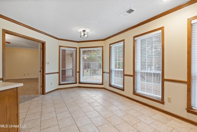 unfurnished dining area featuring crown molding, light tile patterned flooring, and a textured ceiling