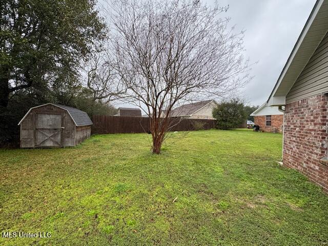 view of yard with a fenced backyard, an outdoor structure, and a storage shed