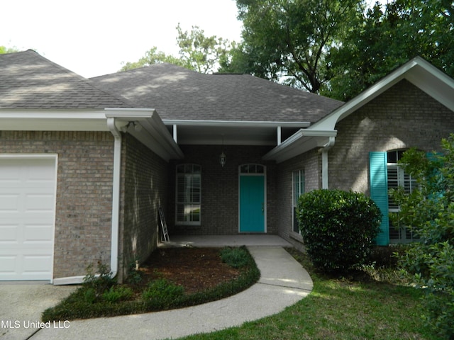 7890 Hilo Way, Diamondhead, MS 39525 - entrance to property featuring an attached garage, brick siding, and roof with shingles