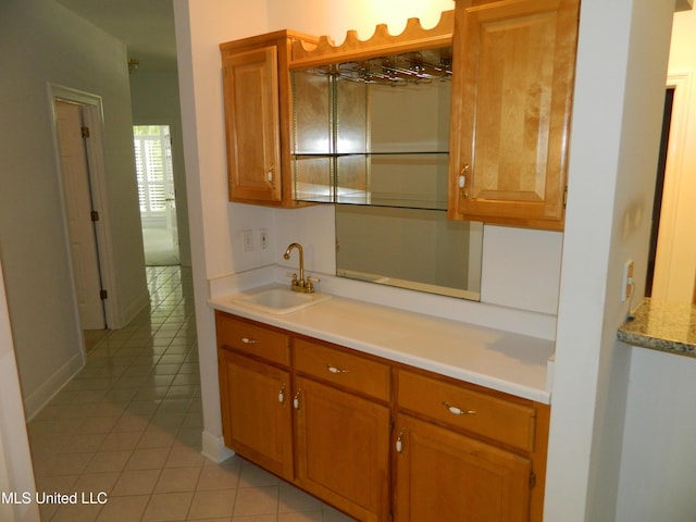7890 Hilo Way, Diamondhead, MS 39525 - kitchen featuring a sink, light tile patterned flooring, light countertops, brown cabinets, and baseboards