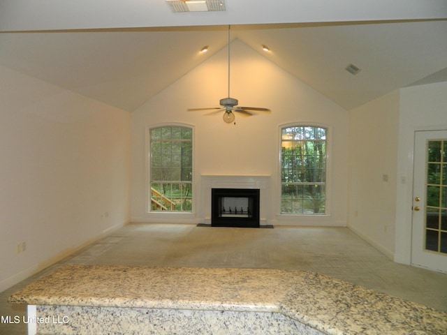 7890 Hilo Way, Diamondhead, MS 39525 - unfurnished living room featuring light colored carpet, a fireplace with flush hearth, a ceiling fan, high vaulted ceiling, and plenty of natural light