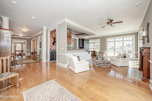 1401 Ladnier Rd, Gautier, MS 39553 - living room featuring ornate columns, ceiling fan, light wood-type flooring, and ornamental molding