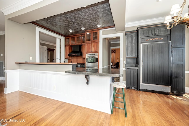 1401 Ladnier Rd, Gautier, MS 39553 - kitchen with an ornate ceiling, crown molding, a chandelier, a breakfast bar area, and extractor fan