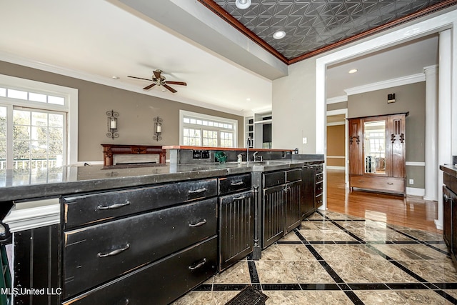 1401 Ladnier Rd, Gautier, MS 39553 - kitchen featuring baseboards, crown molding, a healthy amount of sunlight, and dark cabinetry