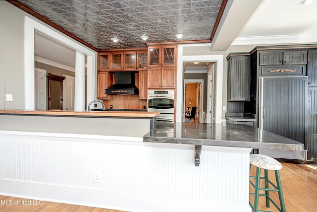 1401 Ladnier Rd, Gautier, MS 39553 - kitchen with an ornate ceiling, light wood-style flooring, custom range hood, ornamental molding, and oven
