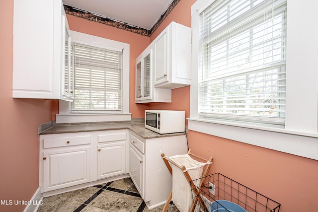 1401 Ladnier Rd, Gautier, MS 39553 - kitchen with white cabinetry, white microwave, and baseboards
