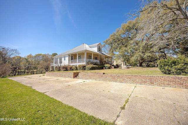 1401 Ladnier Rd, Gautier, MS 39553 - view of side of home featuring covered porch, metal roof, and a yard