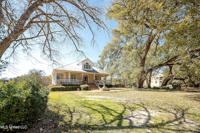 1401 Ladnier Rd, Gautier, MS 39553 - cape cod house with metal roof, a front yard, and covered porch