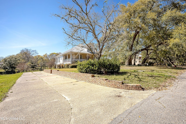 1401 Ladnier Rd, Gautier, MS 39553 - view of front of home featuring a front lawn, covered porch, and concrete driveway