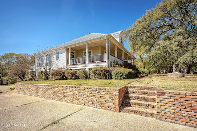 1401 Ladnier Rd, Gautier, MS 39553 - view of side of property with a lawn, covered porch, and metal roof