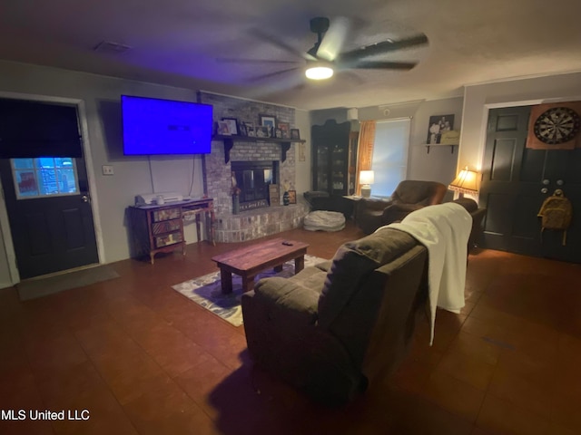 tiled living room featuring a fireplace and ceiling fan