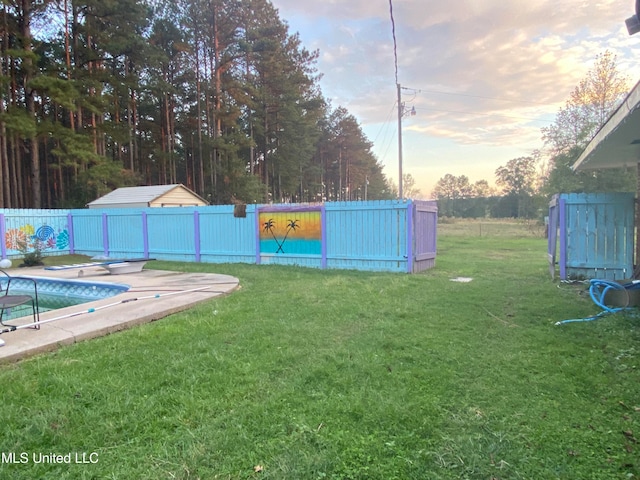 yard at dusk with a fenced in pool