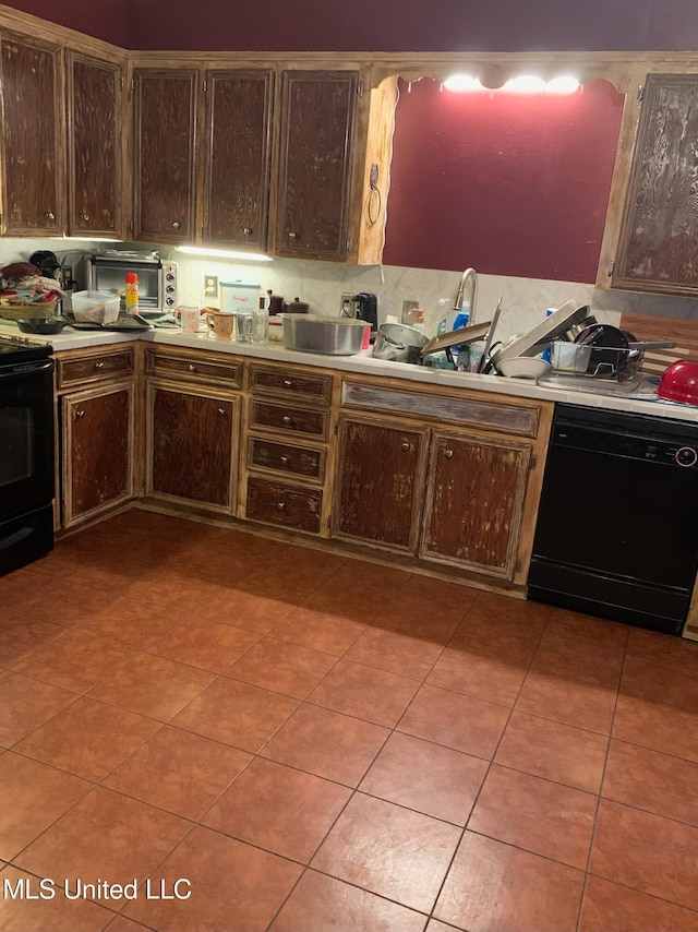 kitchen featuring dark brown cabinetry, black appliances, and backsplash