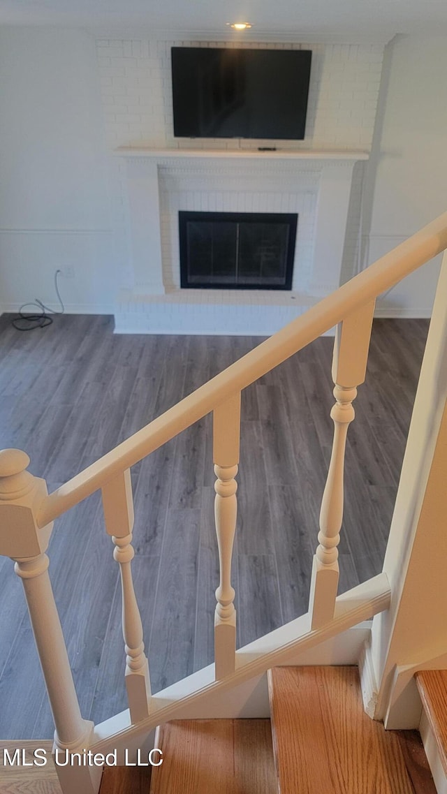 details with hardwood / wood-style flooring and a brick fireplace