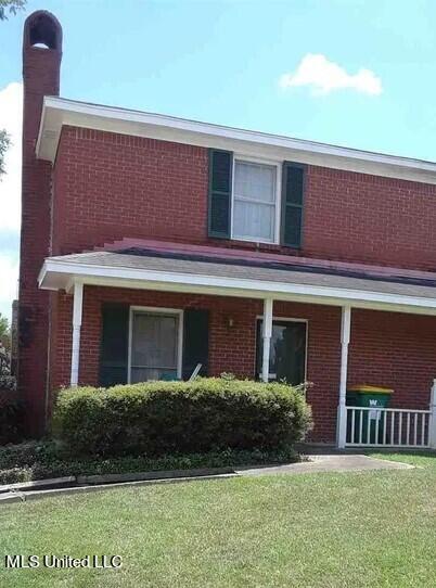 exterior space with a porch and a front yard