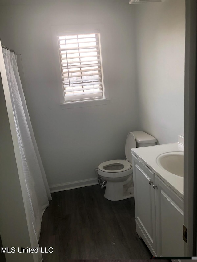 bathroom with hardwood / wood-style floors, vanity, and toilet