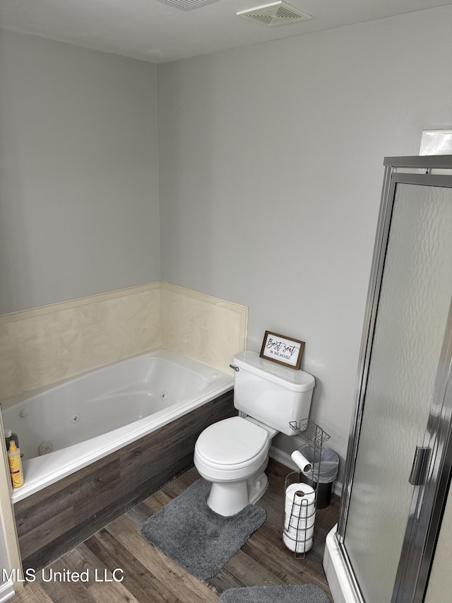 bathroom featuring visible vents, a shower stall, wood finished floors, a whirlpool tub, and toilet