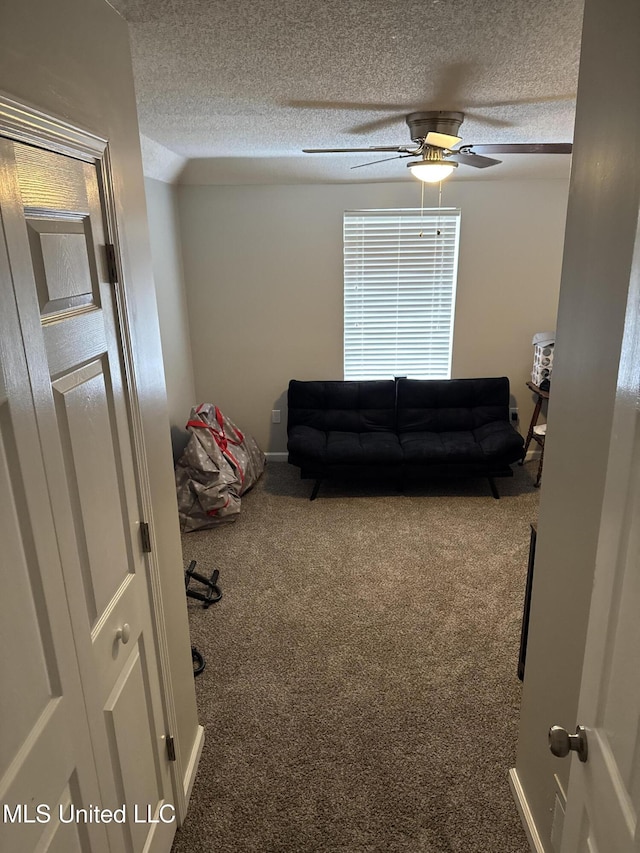 interior space featuring carpet floors, a textured ceiling, and ceiling fan