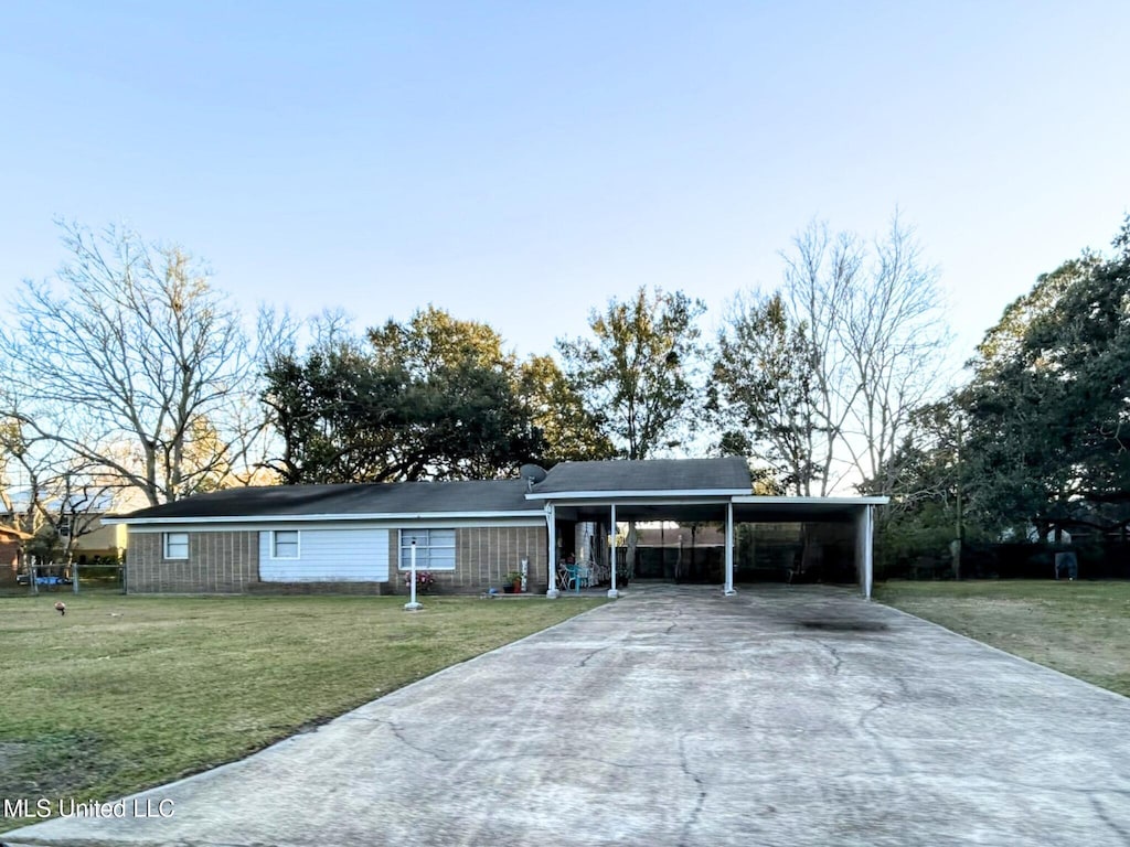 ranch-style house featuring a front lawn and a carport