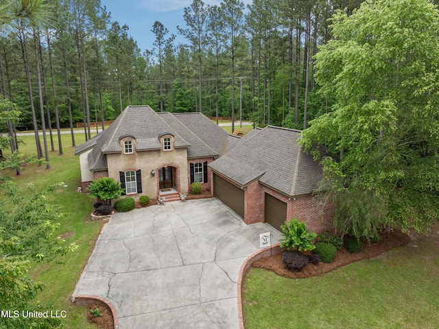 10 Magnolia Crossing Rd, Sumrall, MS 39482 - french provincial home with a garage, brick siding, concrete driveway, a front lawn, and roof with shingles