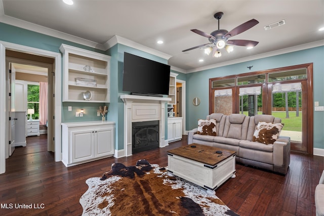 10 Magnolia Crossing Rd, Sumrall, MS 39482 - living area featuring crown molding, a ceiling fan, dark wood-type flooring, a glass covered fireplace, and baseboards
