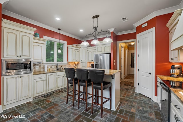 10 Magnolia Crossing Rd, Sumrall, MS 39482 - kitchen with stainless steel appliances, cream cabinetry, decorative backsplash, ornamental molding, and recessed lighting