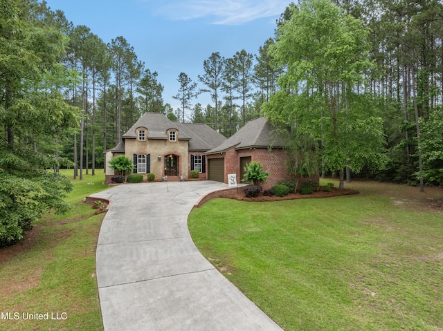 10 Magnolia Crossing Rd, Sumrall, MS 39482 - french country style house featuring a garage, driveway, a front lawn, brick siding, and roof with shingles