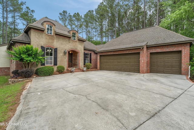 10 Magnolia Crossing Rd, Sumrall, MS 39482 - french country inspired facade with driveway, roof with shingles, an attached garage, and brick siding