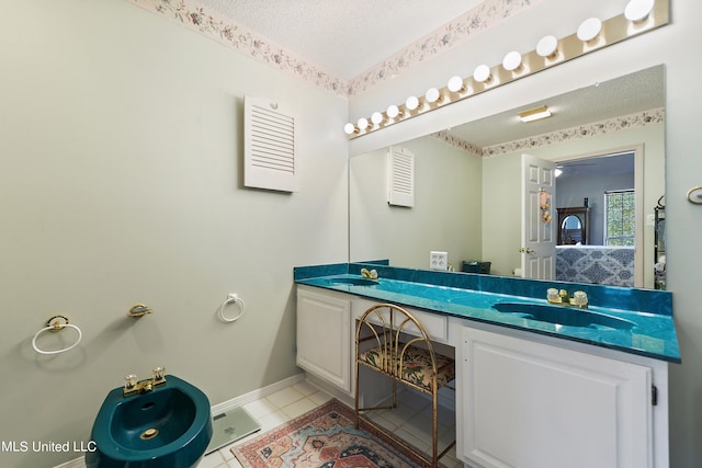 bathroom with vanity, a textured ceiling, tile patterned floors, and a bidet