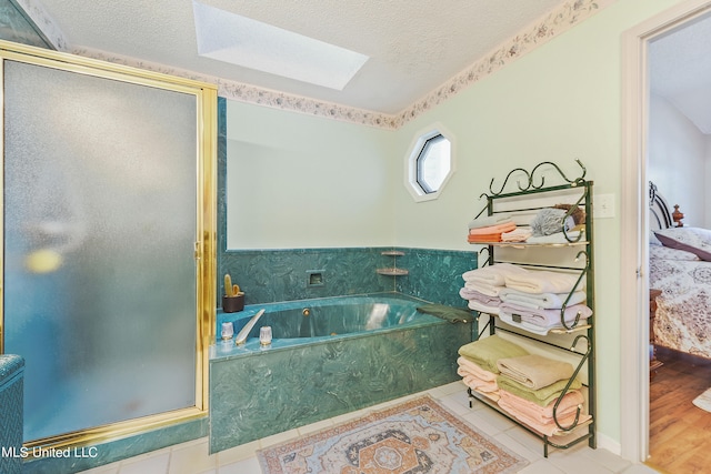 bathroom featuring hardwood / wood-style floors, shower with separate bathtub, a textured ceiling, and a skylight