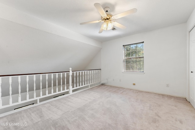 additional living space featuring lofted ceiling, light colored carpet, and ceiling fan