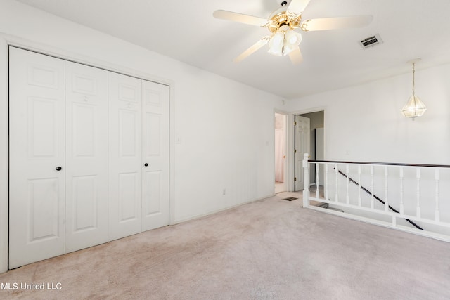 unfurnished bedroom with carpet flooring, a closet, and ceiling fan