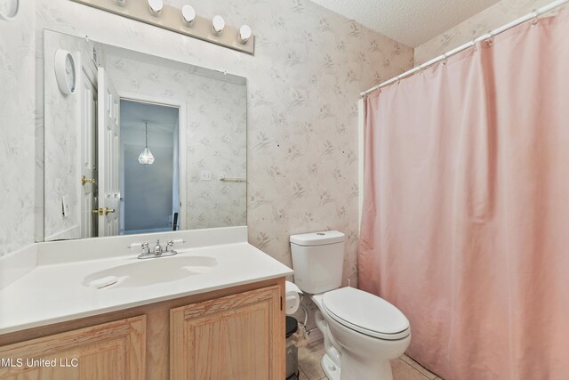 bathroom with a textured ceiling, walk in shower, toilet, vanity, and tile patterned flooring