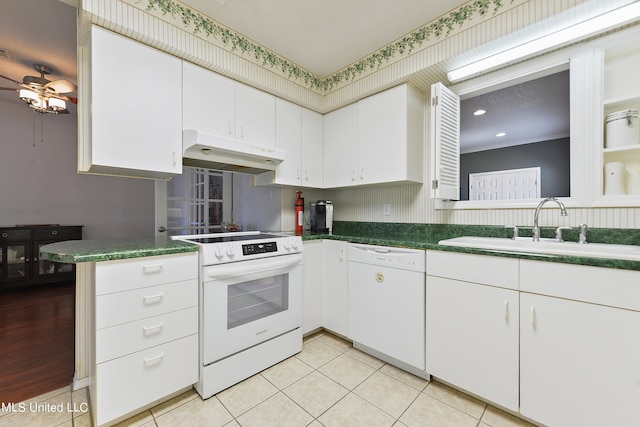 kitchen featuring kitchen peninsula, sink, light tile patterned floors, white cabinetry, and white appliances