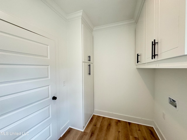 laundry area with cabinets, hookup for a washing machine, dark hardwood / wood-style flooring, and crown molding