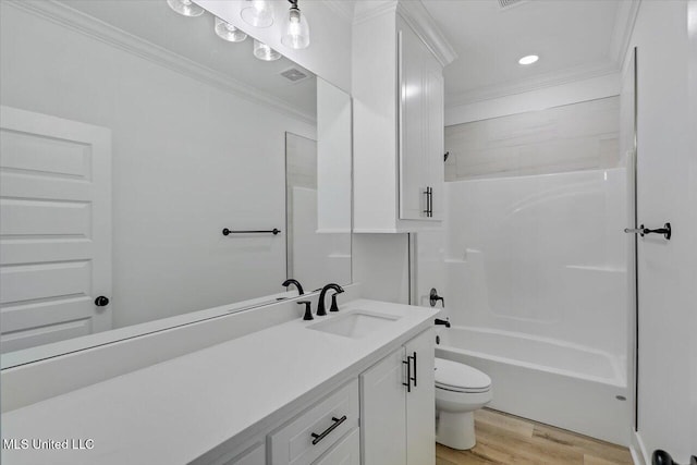 full bathroom with vanity, hardwood / wood-style flooring, toilet, ornamental molding, and tub / shower combination