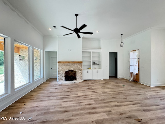 unfurnished living room with ceiling fan, ornamental molding, a fireplace, and light hardwood / wood-style flooring