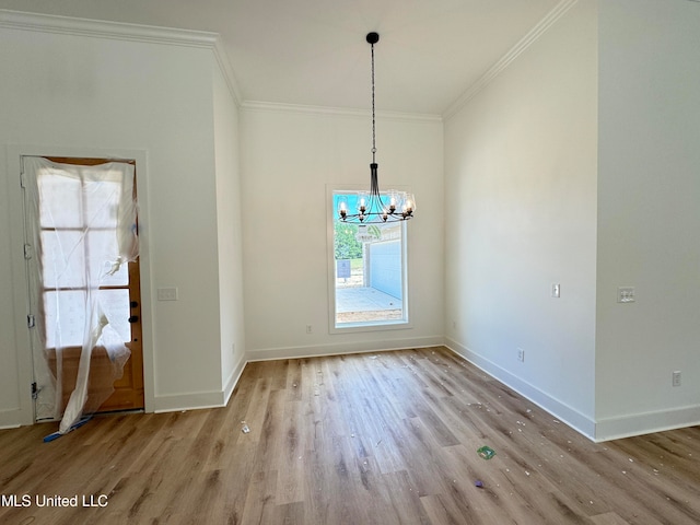 unfurnished dining area with an inviting chandelier, crown molding, and light hardwood / wood-style flooring