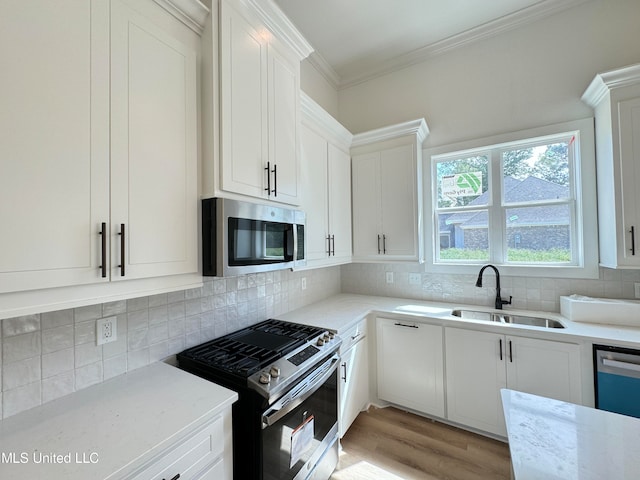 kitchen featuring sink, white cabinets, light wood-type flooring, and appliances with stainless steel finishes