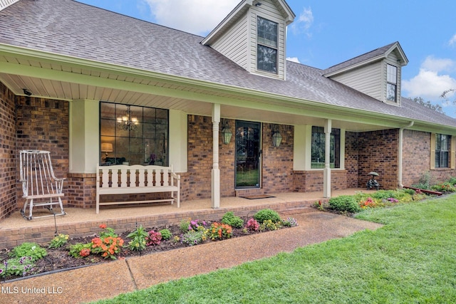 8140 Hunters Hill Cv, Olive Branch, MS 38654 - doorway to property with covered porch, roof with shingles, brick siding, and a lawn