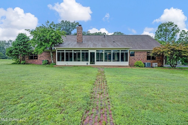 8140 Hunters Hill Cv, Olive Branch, MS 38654 - rear view of house with a sunroom, a lawn, brick siding, and a chimney