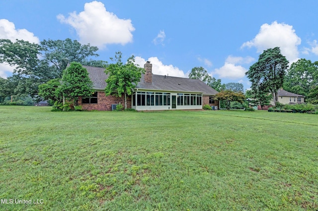 8140 Hunters Hill Cv, Olive Branch, MS 38654 - back of house featuring a lawn, brick siding, a chimney, and a sunroom