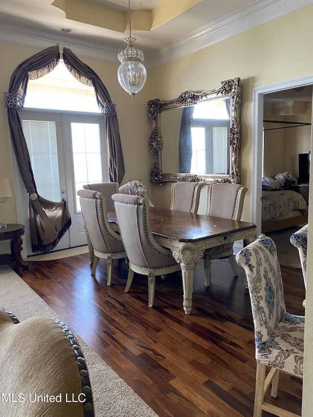dining space featuring hardwood / wood-style flooring, a chandelier, and crown molding