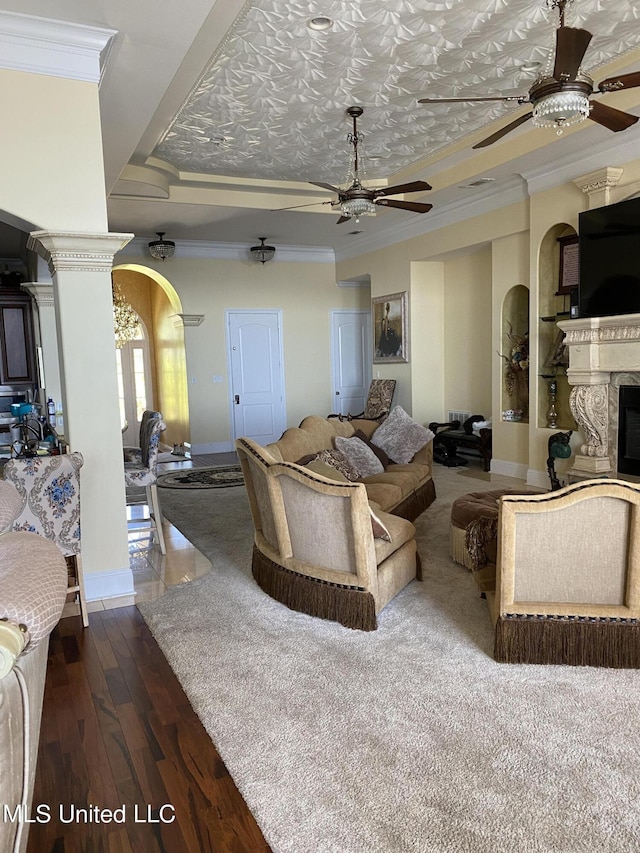 living room with arched walkways, ornamental molding, hardwood / wood-style flooring, and ceiling fan