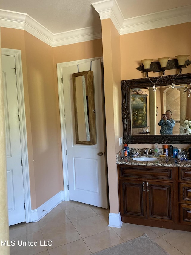 bathroom featuring baseboards, vanity, tile patterned flooring, and crown molding