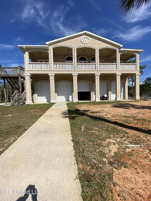 view of front of house featuring stairway, a balcony, and stucco siding