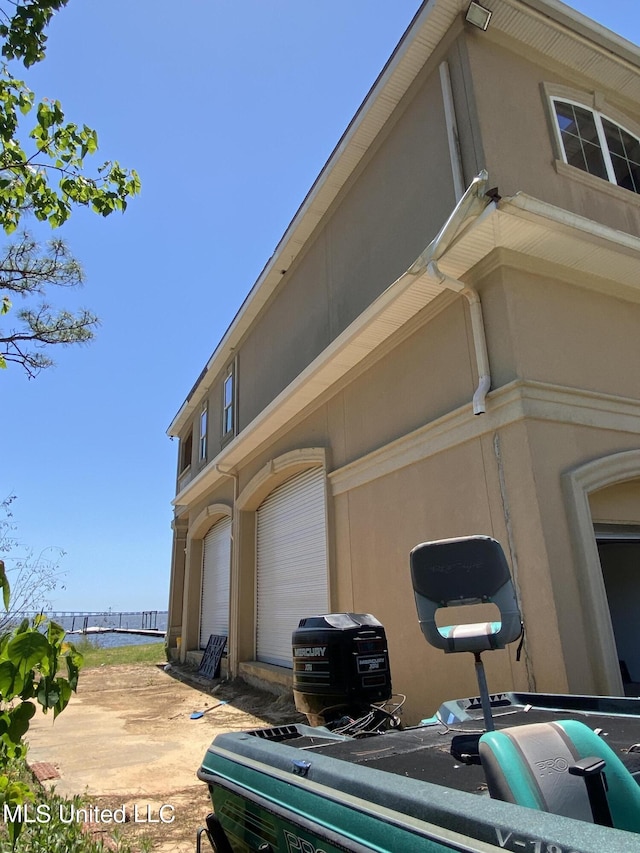 view of side of home with a garage and stucco siding